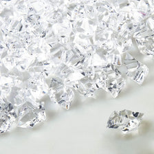 Crushed clear crystal ice stones scattered on a white surface.