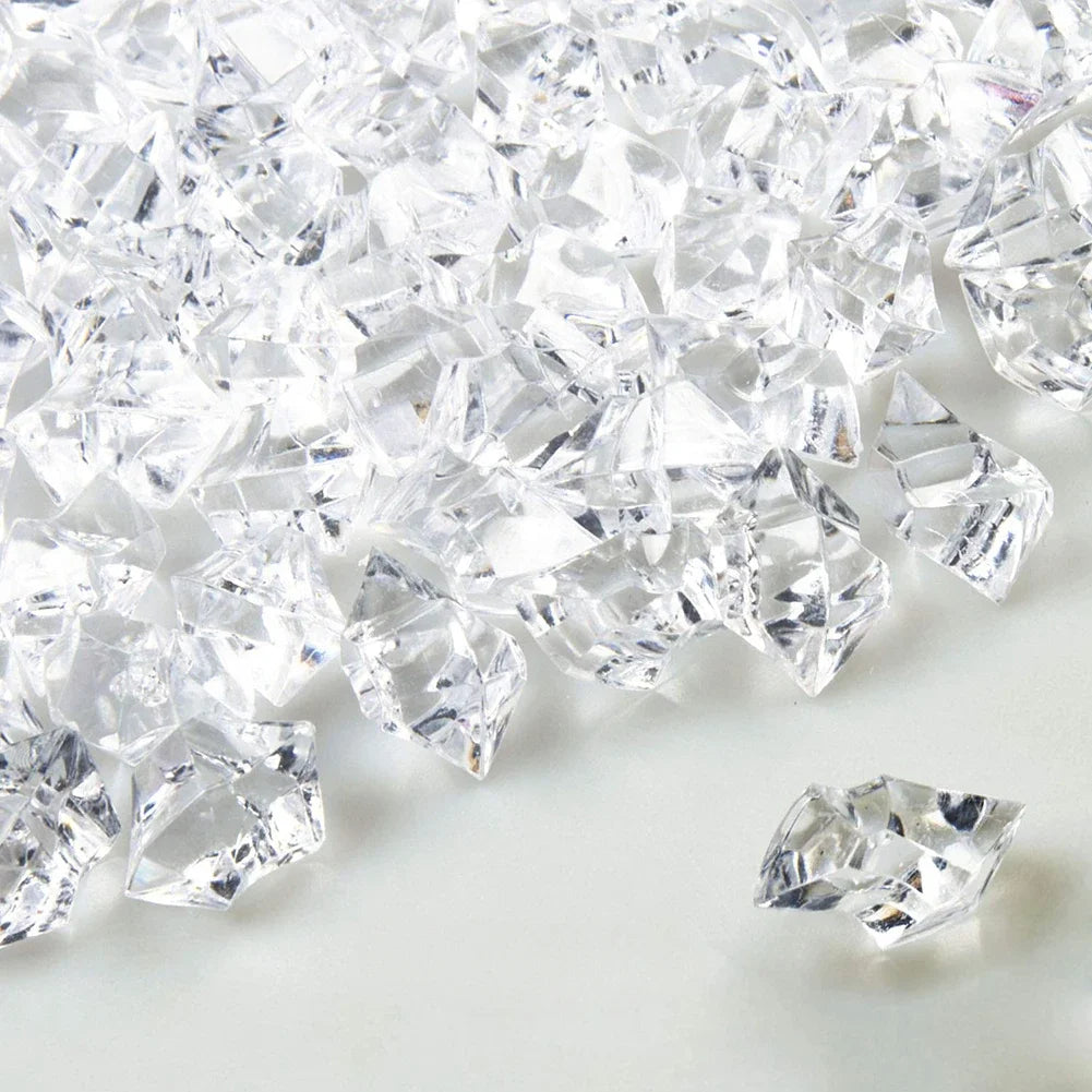 Crushed clear crystal ice stones scattered on a white surface.