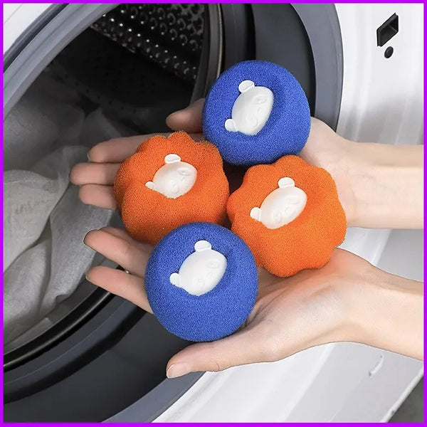 Hands are holding several blue and orange laundry balls with white foam inserts inside a washing machine drum.