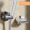 A close-up view of a chrome shower head holder with an adjustable suction cup mechanism mounted on a marble surface.