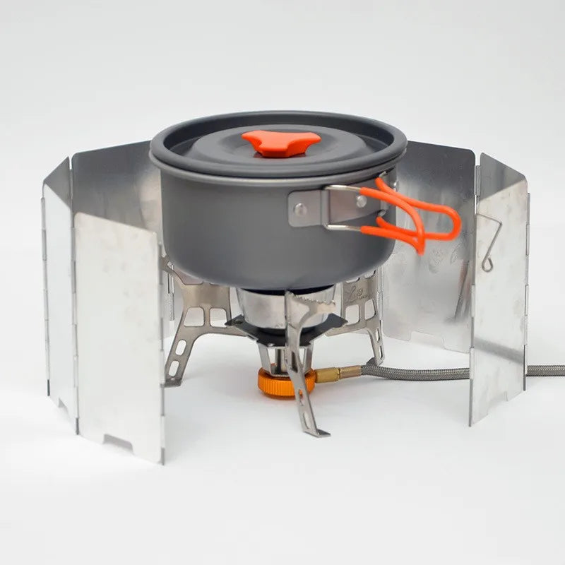 A multi-plate outdoor gas stove wind shield with a dark pot and orange handle is shown on a white background.