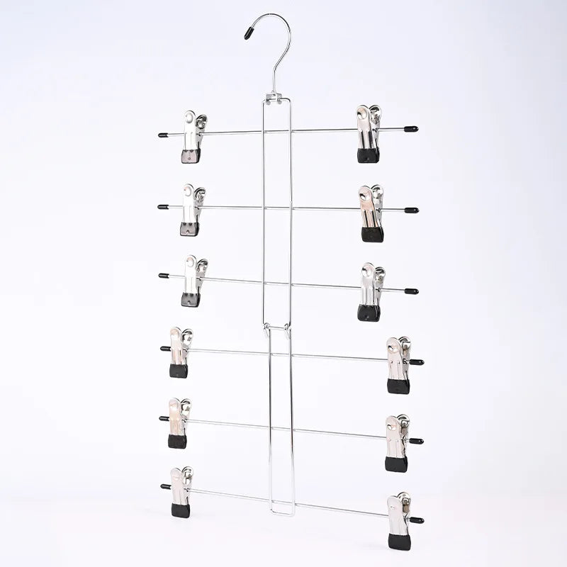 A silver adjustable pants hanger with swivel clips hanging from a hook.
