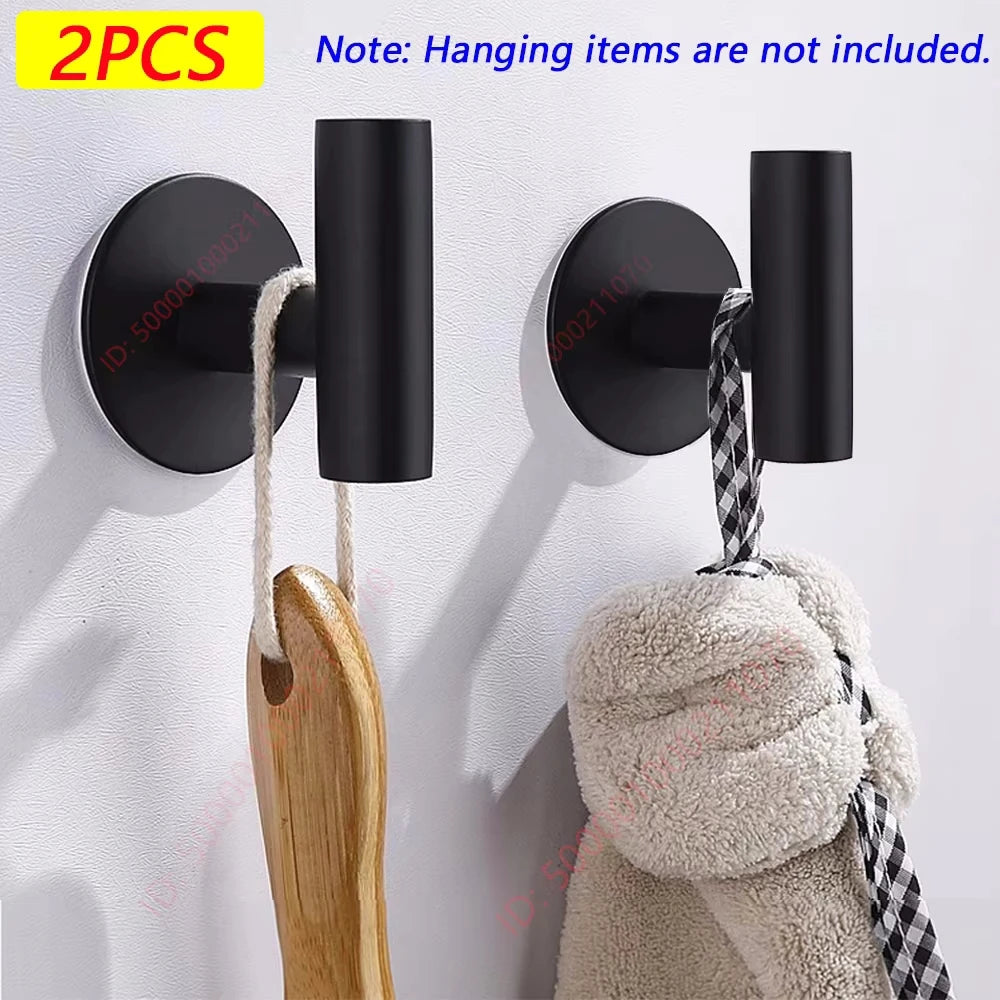 Dos toalleros adhesivos de acero inoxidable negro con perchas de madera montados en una pared blanca.