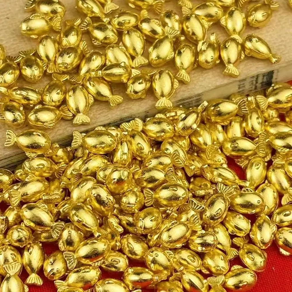 A pile of small, shiny gold bar decorative ornaments.
