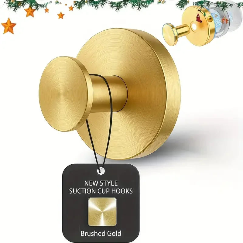 A brushed gold suction cup hook fixture mounted on a wall, shown with its packaging tag.