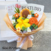 A bouquet of handmade crochet flowers in shades of orange and yellow, wrapped in brown paper.