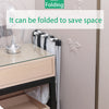 A foldable laundry basket is shown next to a bedside table, demonstrating how it can be folded to save space.