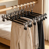 A set of black stainless steel adjustable clothing hangers displayed on a wooden rack.