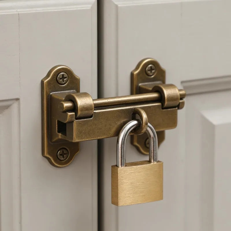 Un mini ensemble de serrure en laiton avec un cadenas est monté sur un cadre de porte blanc.