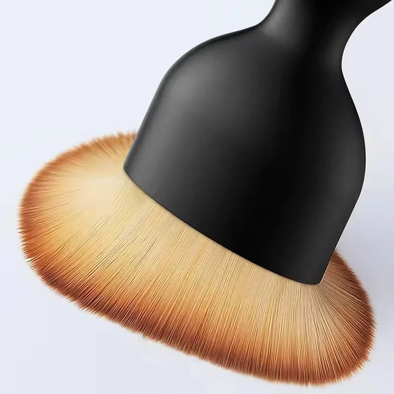 A close-up view of a black multi-surface cleaning brush with a golden-brown bristled head.