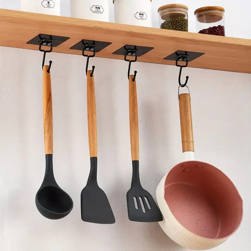 A set of five wooden and black silicone spatulas hanging from a wooden rack on a white wall.