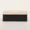 Cepillo de limpieza rectangular con cerdas negras y mango de plástico blanco para limpiar ventanas y rieles.
