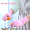 A hand wearing pink nitrile gloves is holding an orange piece of fruit over a metal bowl.