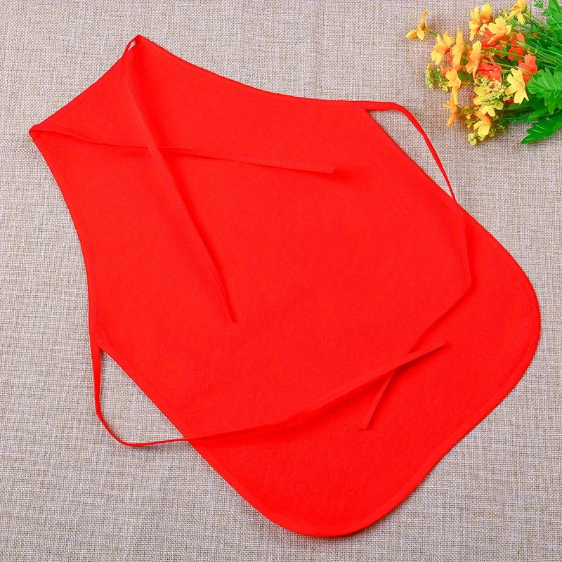 A bright red non-woven craft apron is shown against a beige fabric background with some yellow flowers.