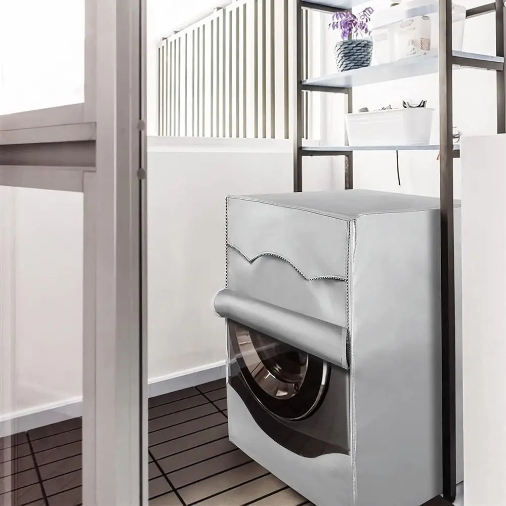 A silver Oxford washing machine cover with a roll edge is displayed inside a modern kitchen cabinet.