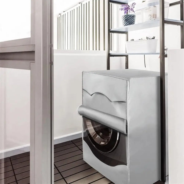 A silver Oxford washing machine cover with a roll edge is displayed inside a modern kitchen cabinet.