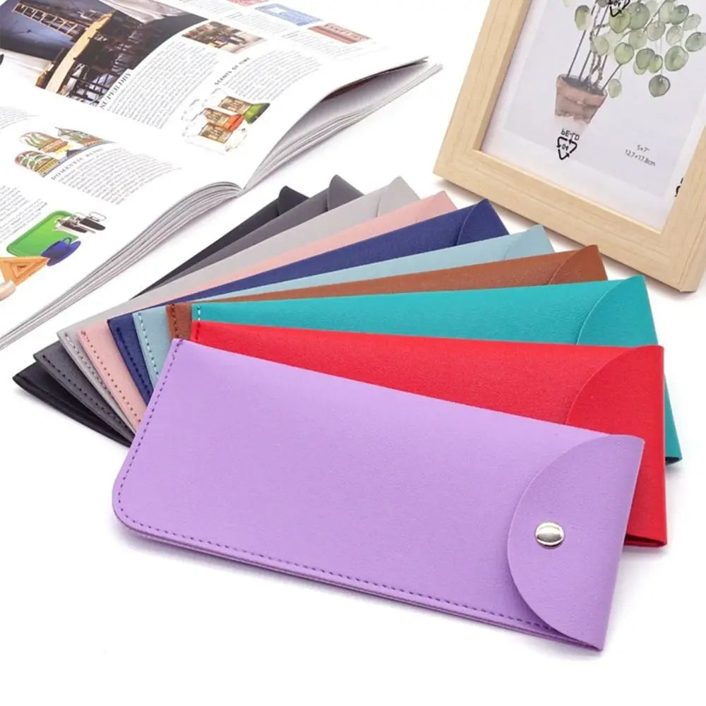 A collection of colorful PU leather eyewear cases and glasses bags displayed next to an open magazine.