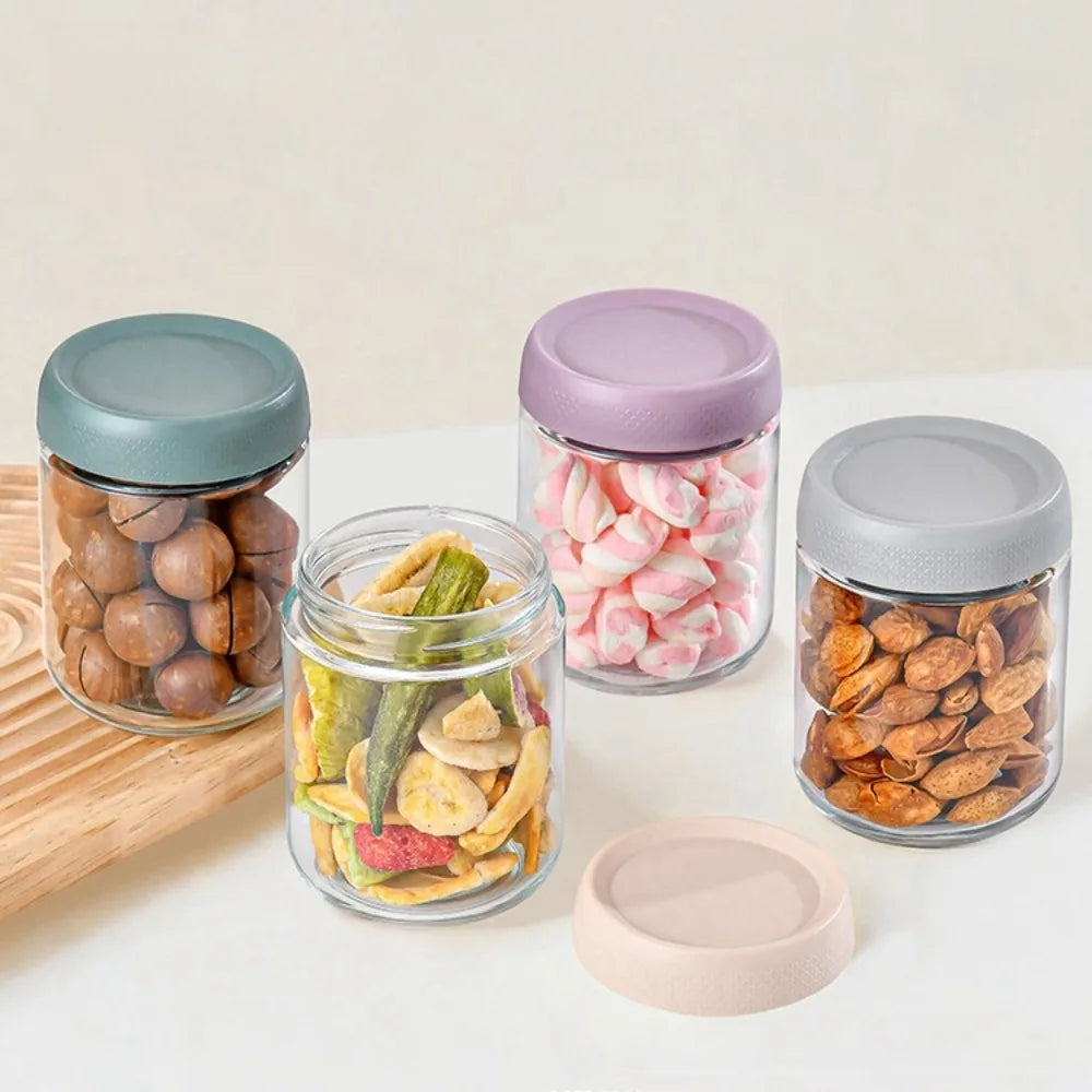 A collection of glass meal prep jars with airtight lids filled with various dried fruits and nuts.