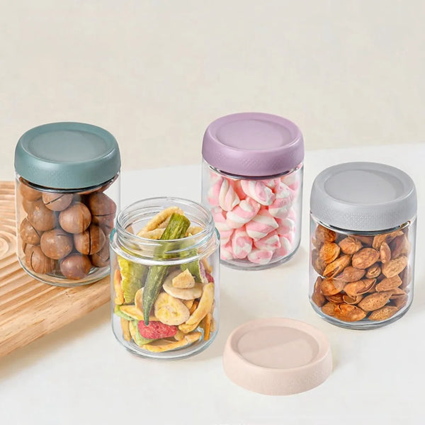 A collection of glass meal prep jars with airtight lids filled with various dried fruits and nuts.