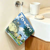 A cute Totoro cartoon-themed fabric hanging towel is displayed on a wall.