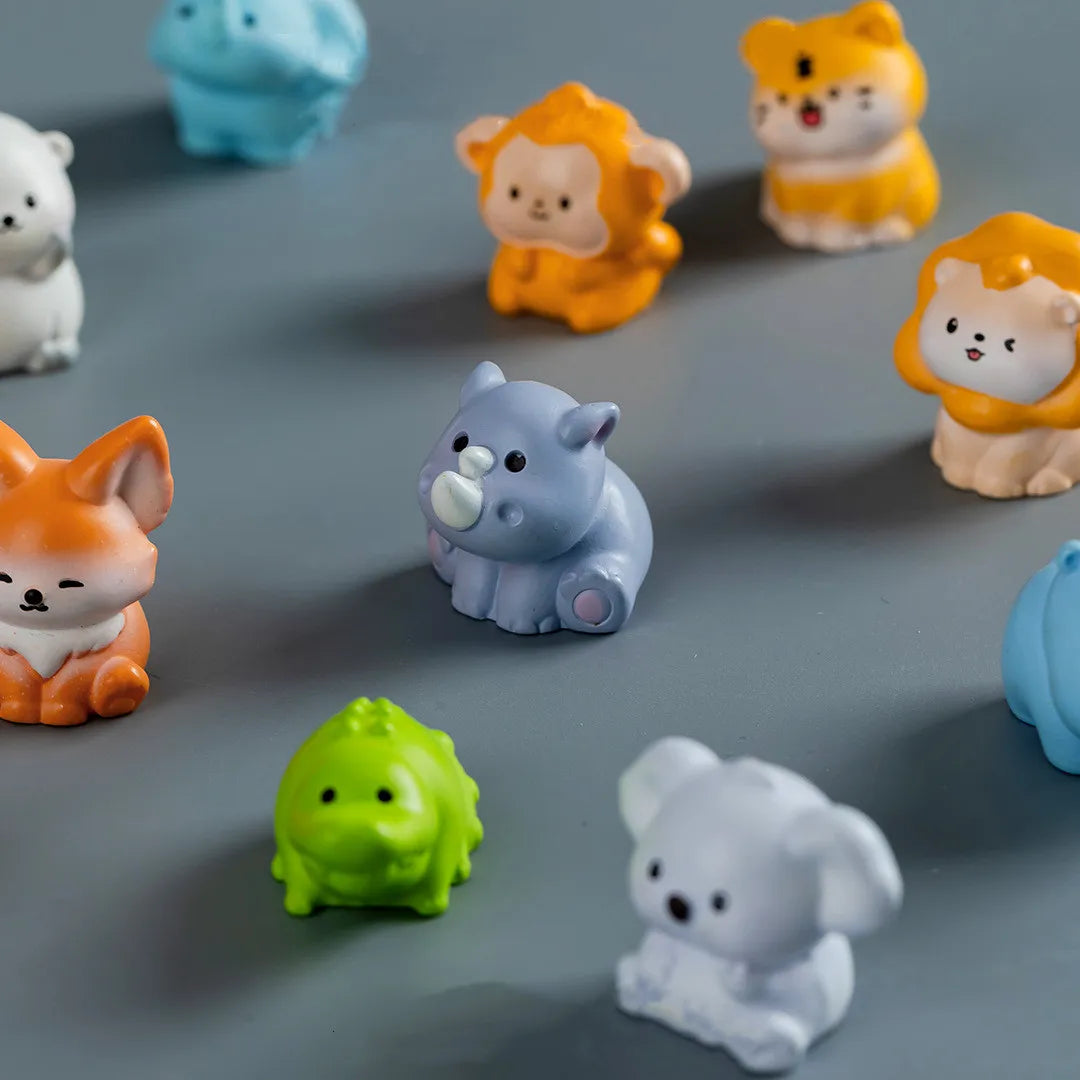A collection of mini resin cartoon animal figurines in various colors including orange, yellow, purple, and white.