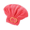 A bright coral pink microfiber hair drying towel cap with a gathered top and a bow detail.