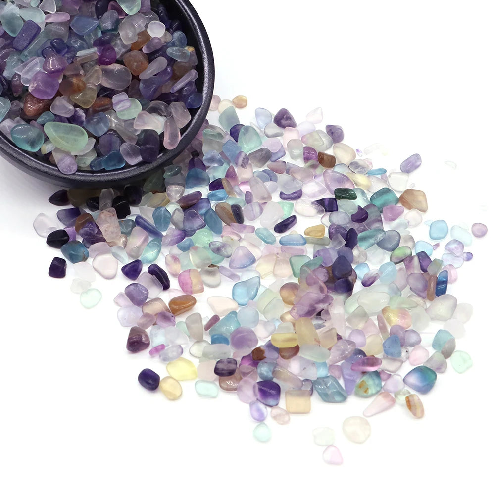 Una colección de cristales de amatista y aguamarina pulidos esparcidos sobre un fondo blanco.