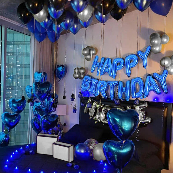 A decorated room with blue balloons and a banner spelling out Happy Birthday