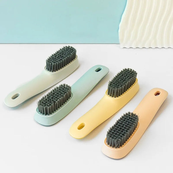 A set of four multi-functional cleaning brushes in pastel colors including light green, blue, yellow, and peach.