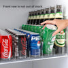 A hand is reaching into a refrigerator shelf displaying various canned and bottled beverages.