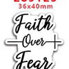 Sticker blanca cortada con texto 'Faith Over Fear' y un signo de más.