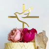 Gold acrylic cross cake topper featuring a silhouette of a dove and a cross on a cake.