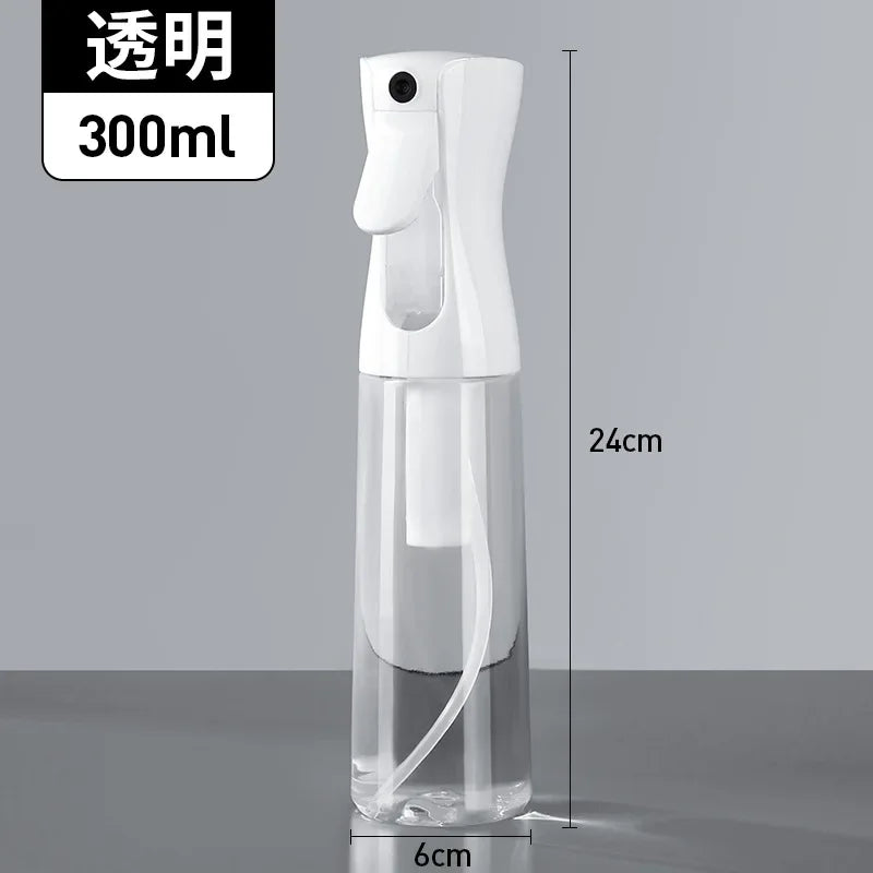 A clear white refillable continuous mist spray bottle with a pump dispenser and a white nozzle, shown against a gray backgrou