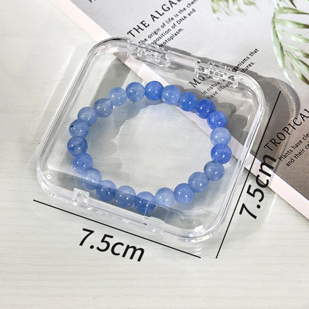 A bracelet of light blue beads is displayed inside a clear plastic jewelry organizer box.