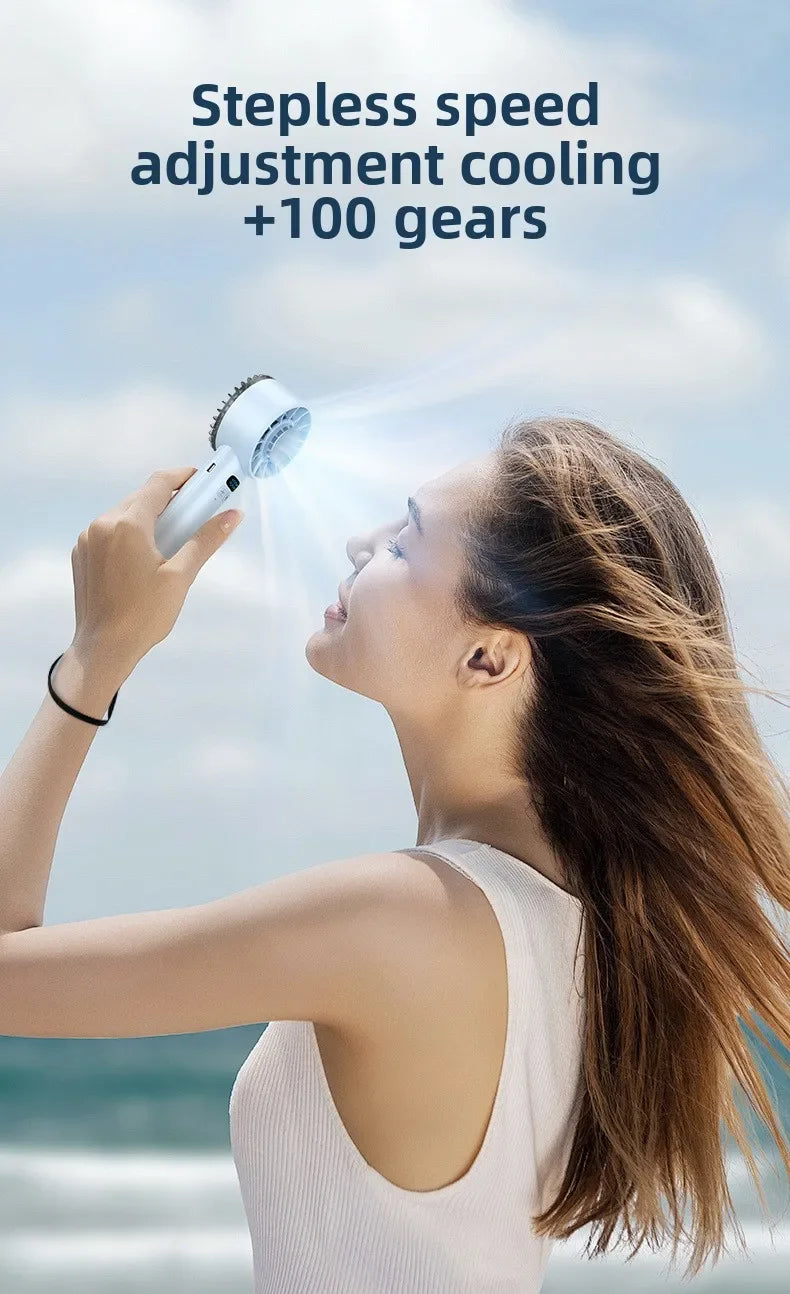 A woman uses an ice compress fan to direct cooling air onto her face outdoors.