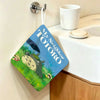 A blue fabric towel featuring a Totoro cartoon character hanging on a wall.