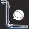 A silver drain auger with a flexible shaft is shown being used to clear debris from a pipe.