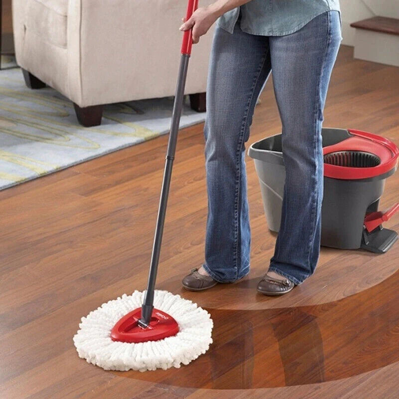 A person is using a red mop with a white microfiber pad on a wooden floor.
