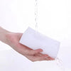 A hand is holding a white cleaning sponge while water drips from above.