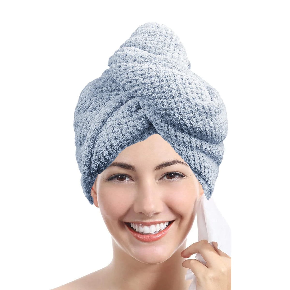 A woman is smiling while wrapping a light blue microfiber hair drying towel around her head.