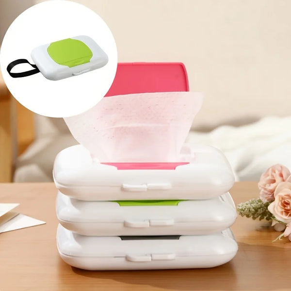 A stack of white reusable wipe dispensers with lime green accents and a pink wipe container on a wooden surface.