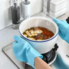 A hand wearing a blue silicone dishwashing glove is holding a white bowl of cooking liquid on a stovetop.
