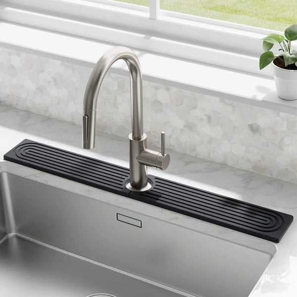 A modern stainless steel faucet mounted on a black mat above a kitchen sink.