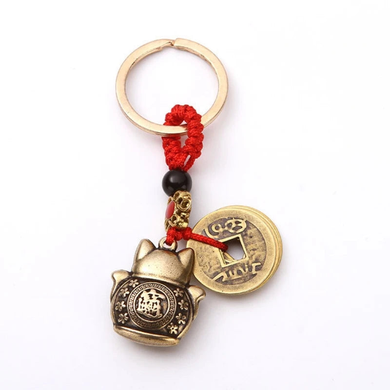 Vintage gold-tone lucky cat keychain with a gold hoop and red cord