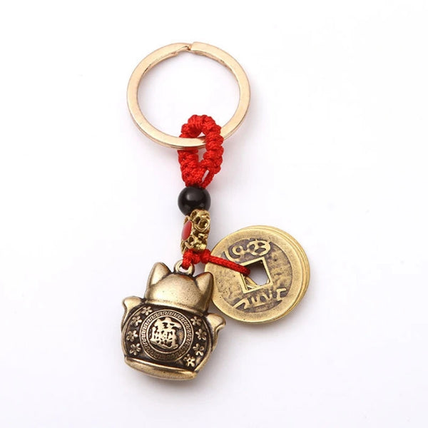 Vintage gold-tone lucky cat keychain with a gold hoop and red cord