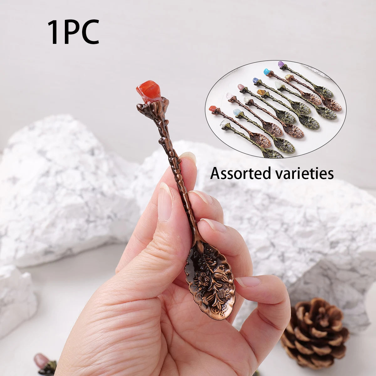 A hand holds a natural crystal spoon with assorted varieties of plant material for energy healing.