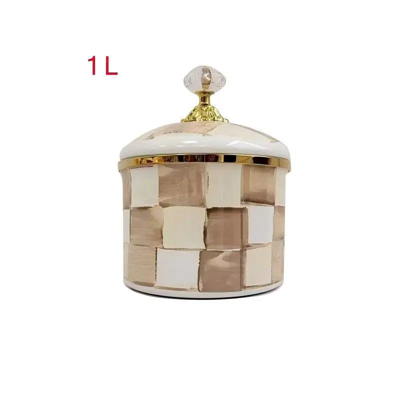 A square storage jar with a lid featuring a gold accent and a checkered pattern of beige and white enamel.
