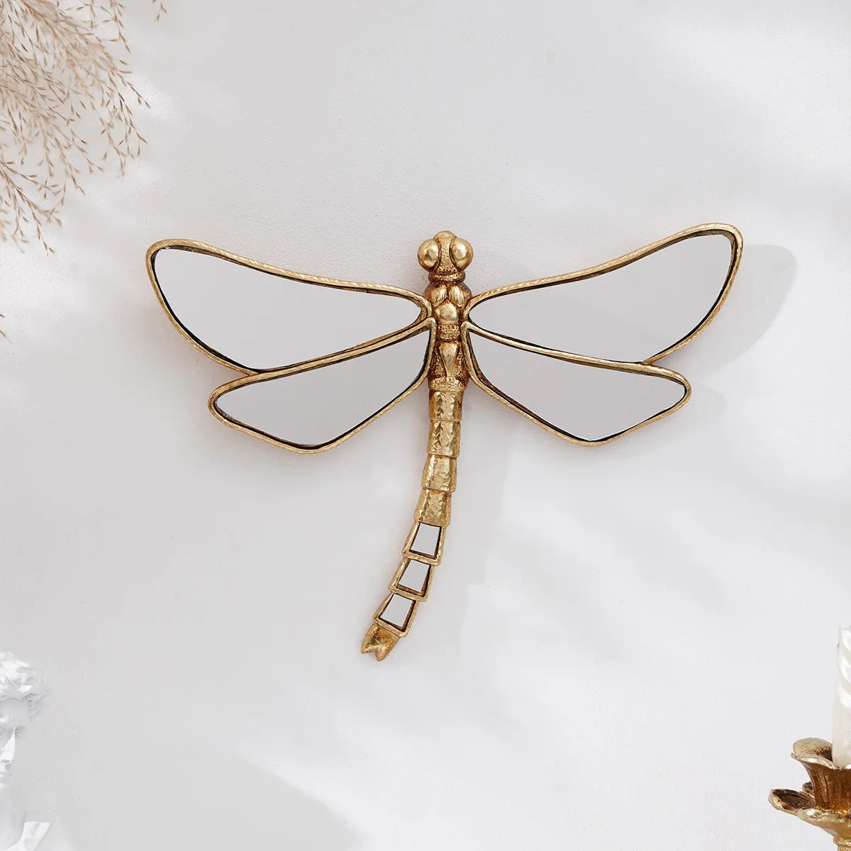 Golden dragonfly mirror wall decor featuring a detailed, gilded dragonfly silhouette.