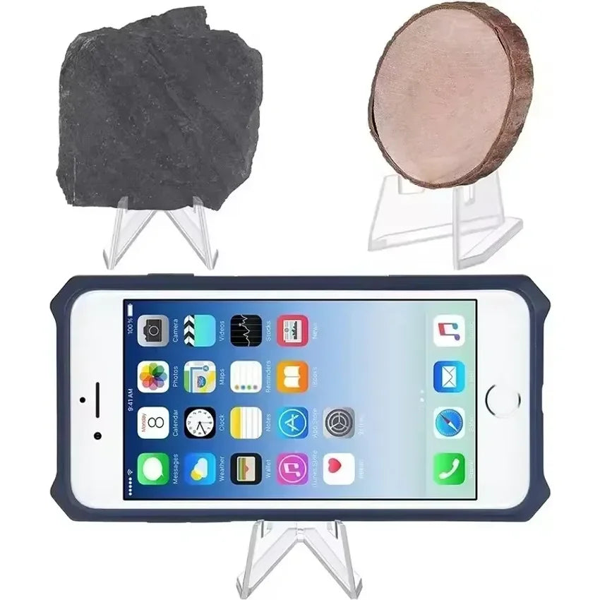 Clear acrylic display stands holding a dark stone and a round, tan object.