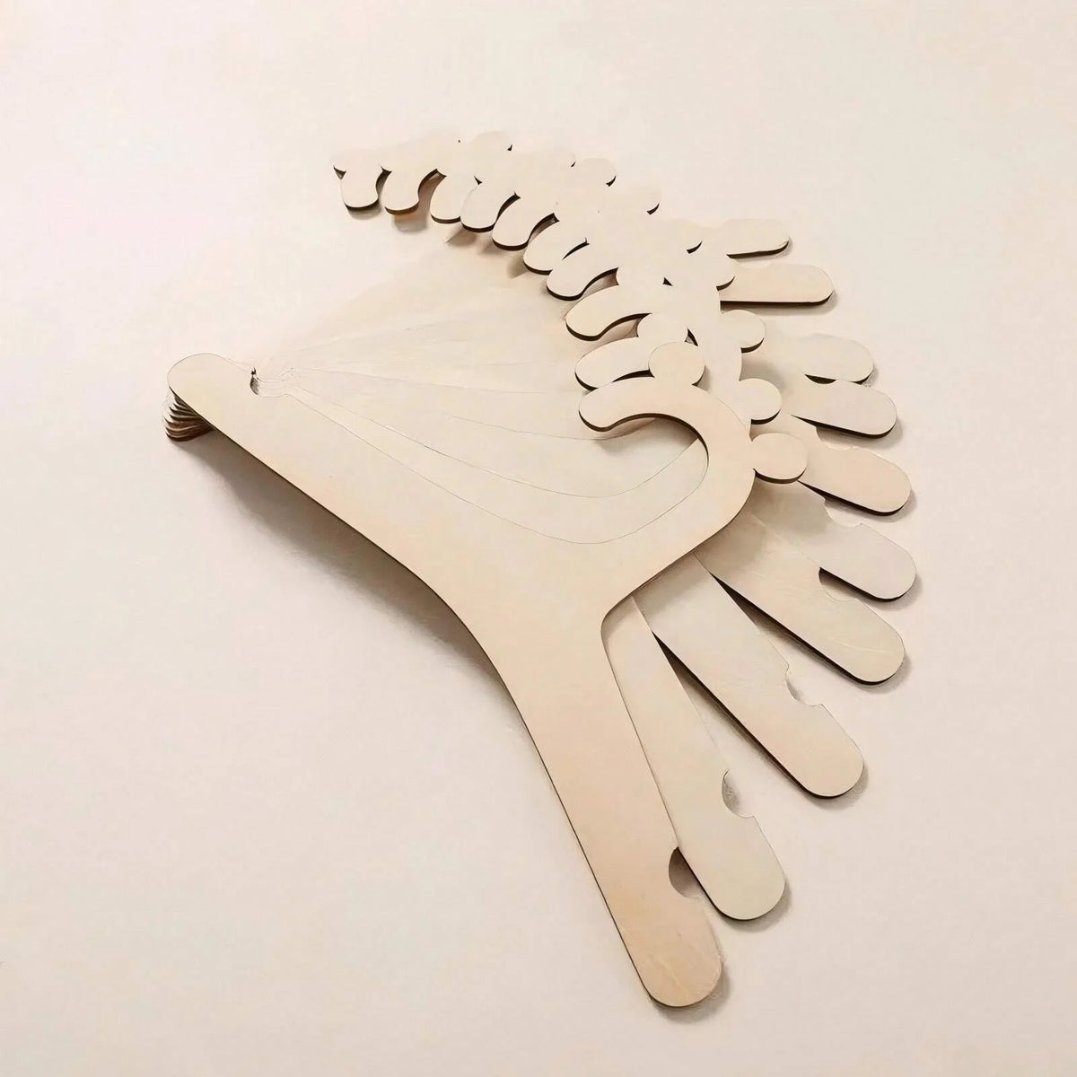 A wooden clothing hanger with multiple curved wooden hangers for kids and apparel